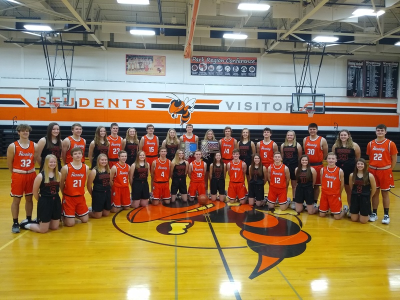 A group photo of the girls and boys basketball teams in the gym