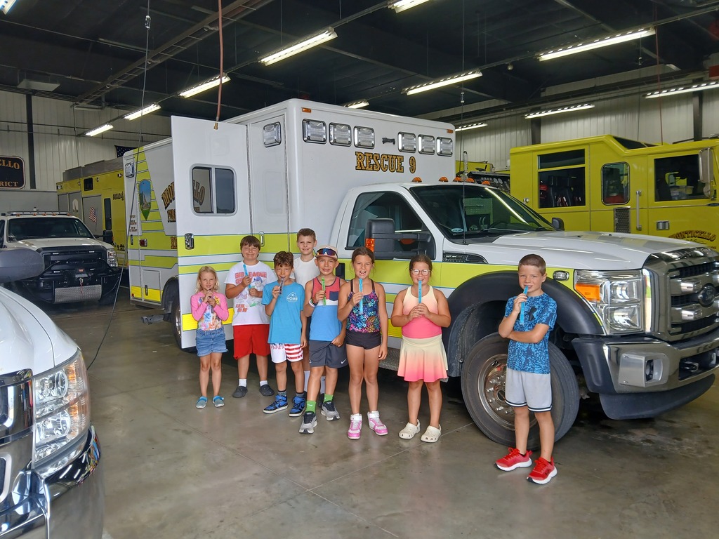students with popsicles in front of an ambulance