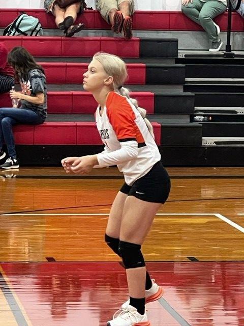 Girl playing volleyball on a court.