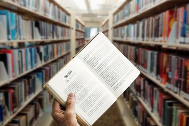 Graphic of a hand holding a library book