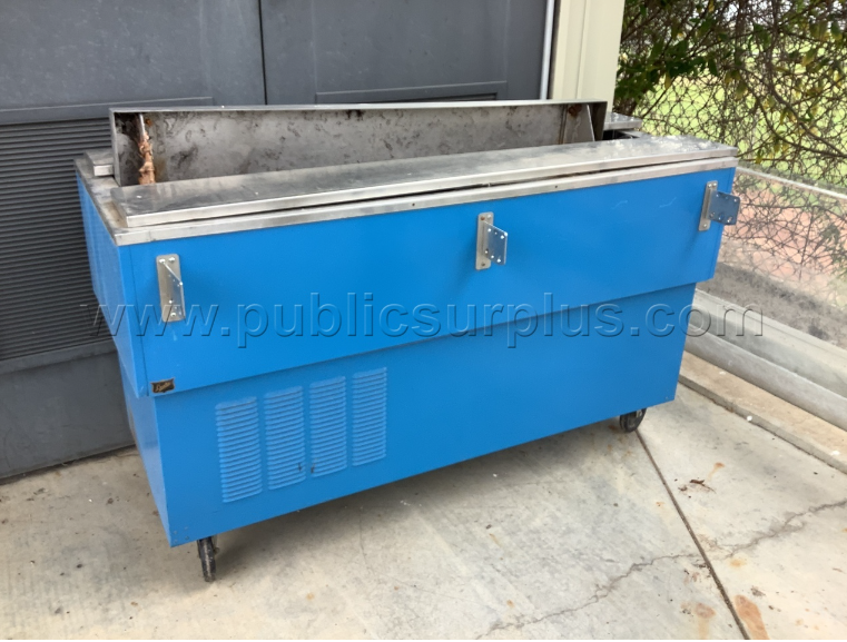 A blue metal cooler placed on a concrete floor, showcasing its sleek design and sturdy construction.