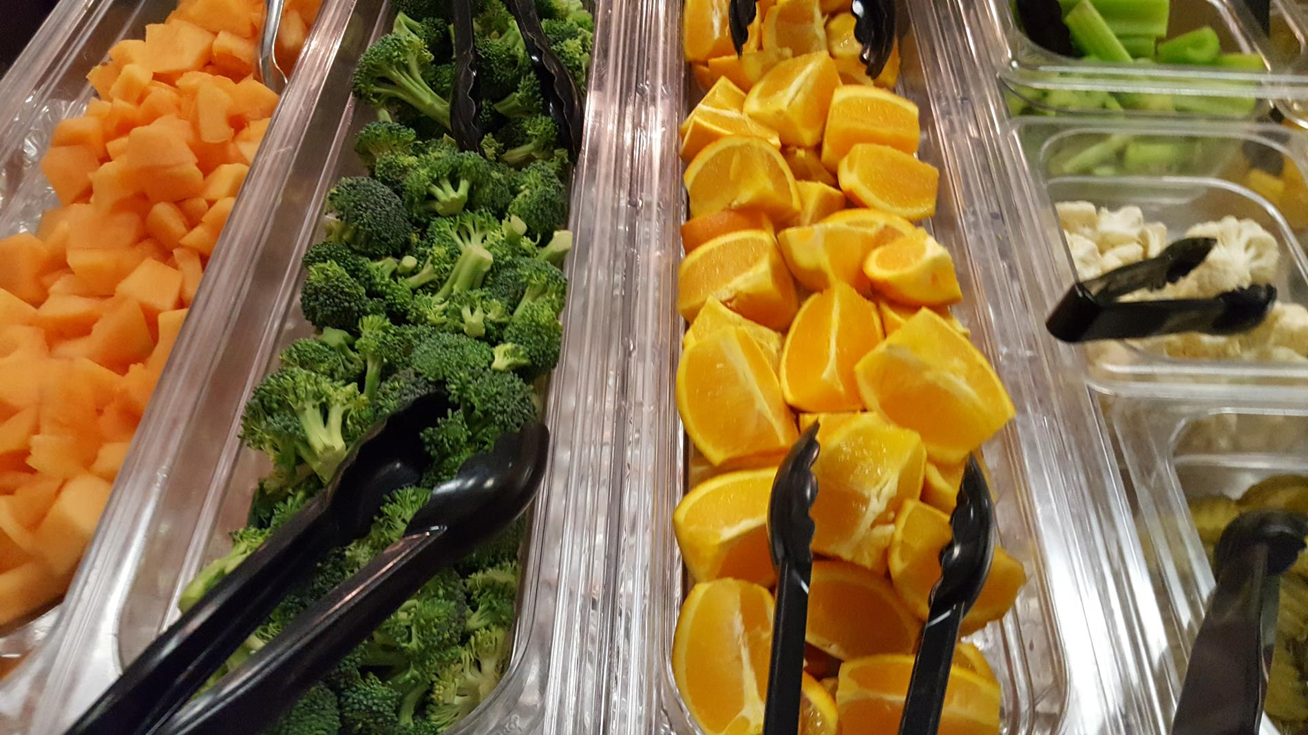 A colorful buffet display featuring an assortment of fresh fruits and vegetables arranged attractively on a table.