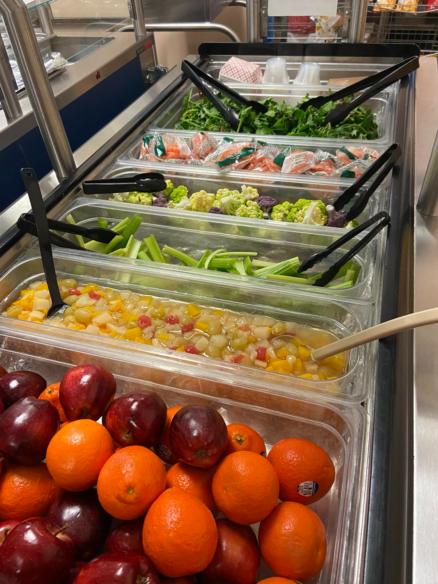 A colorful buffet display featuring an assortment of fresh fruits and vegetables arranged attractively on a table.