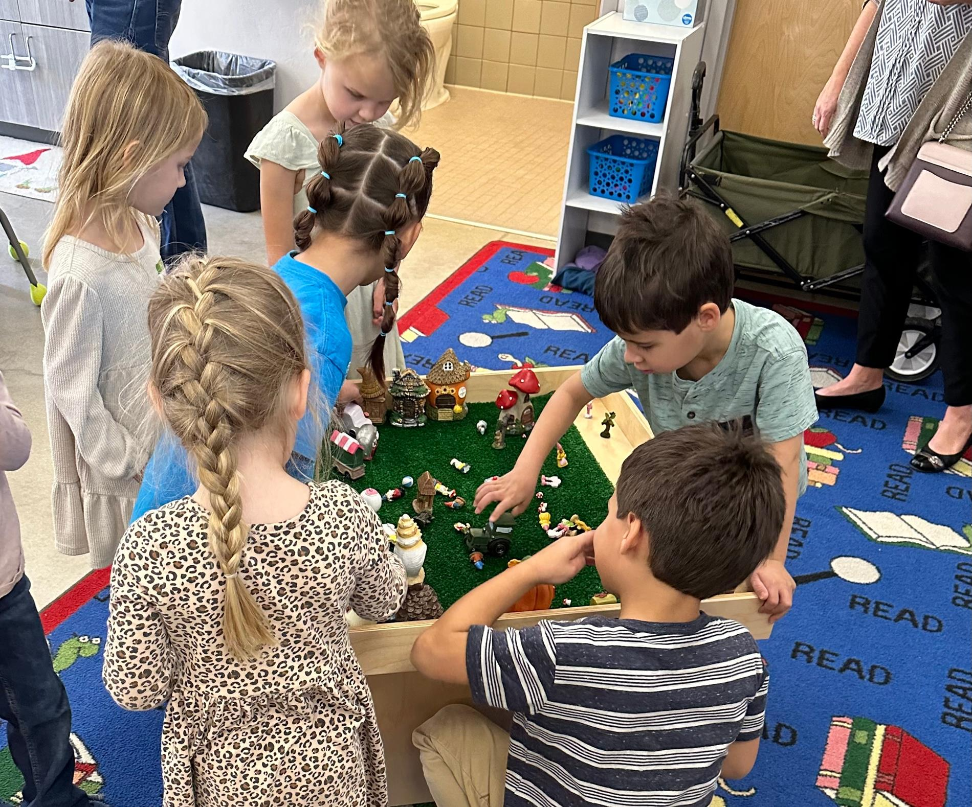 Children engaged in play with colorful LEGO bricks in a bright classroom setting, fostering creativity and teamwork.