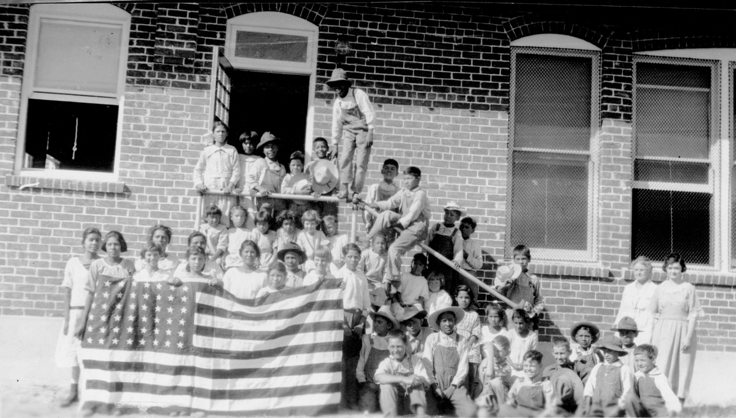 kids in front of one room shool house