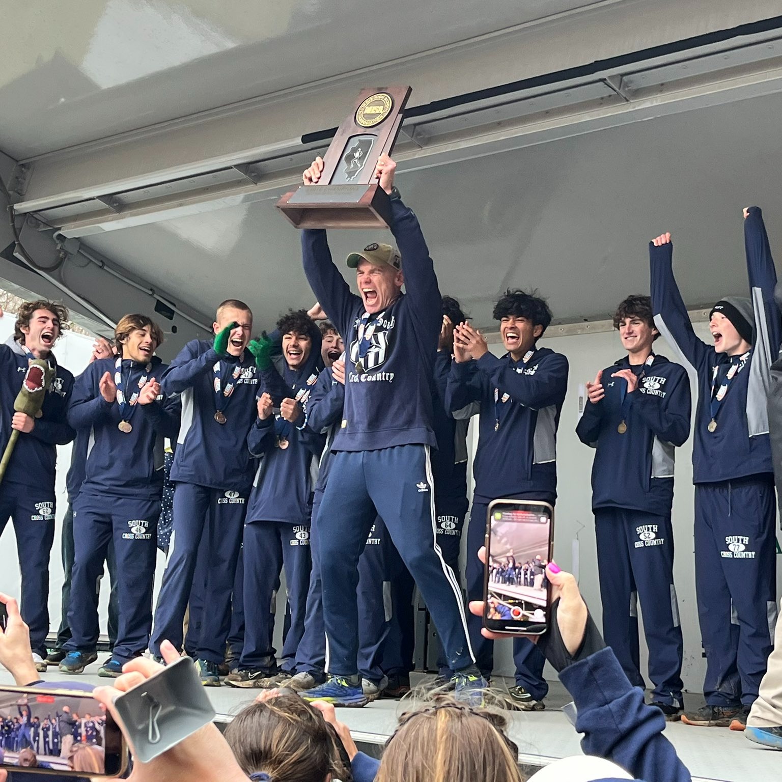PSHS on stage holding trophy
