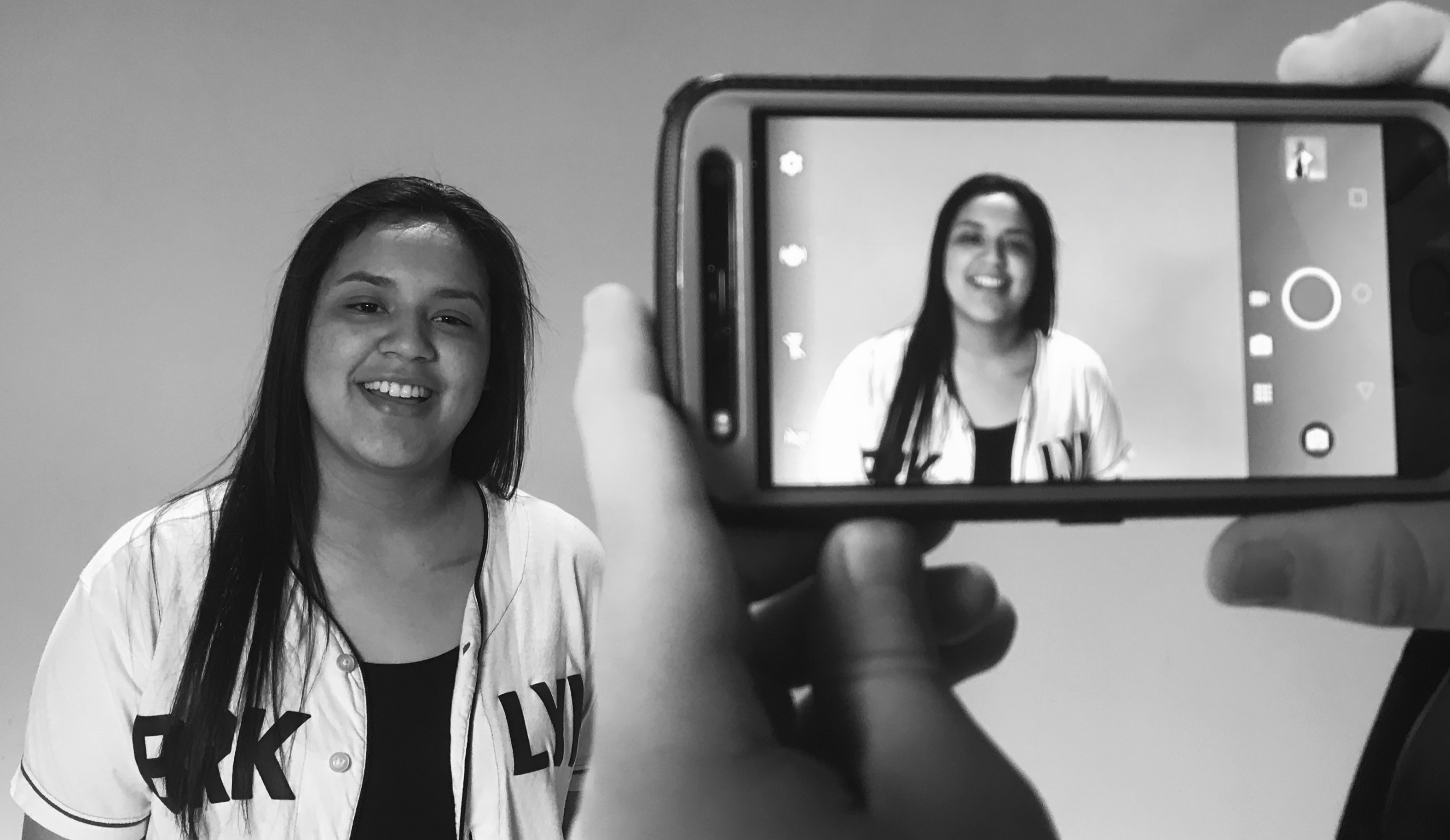 A photo of a student being filmed on a smart phone