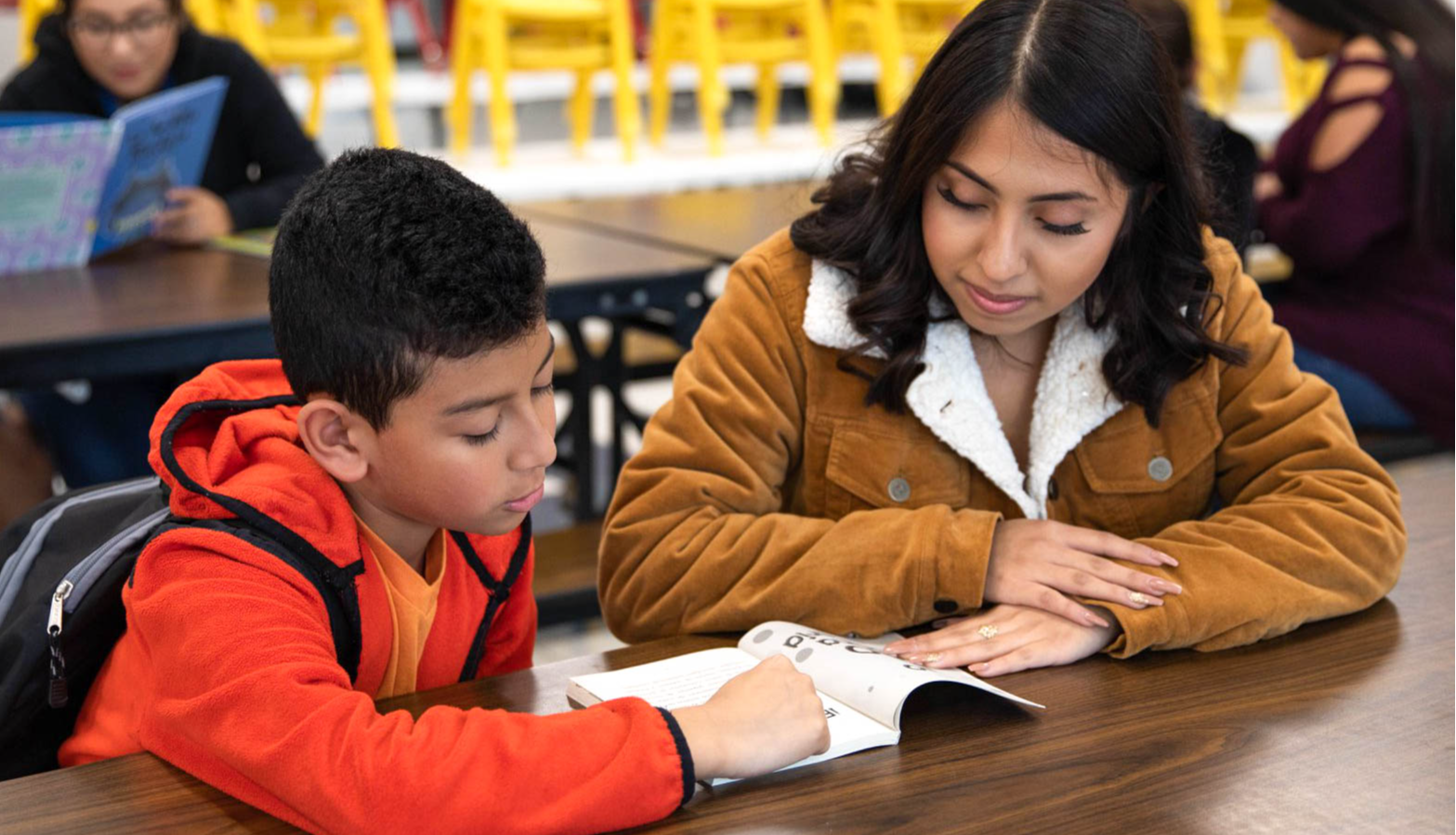 Photo of a teacher with a student reading.