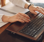 Hands typing on laptop