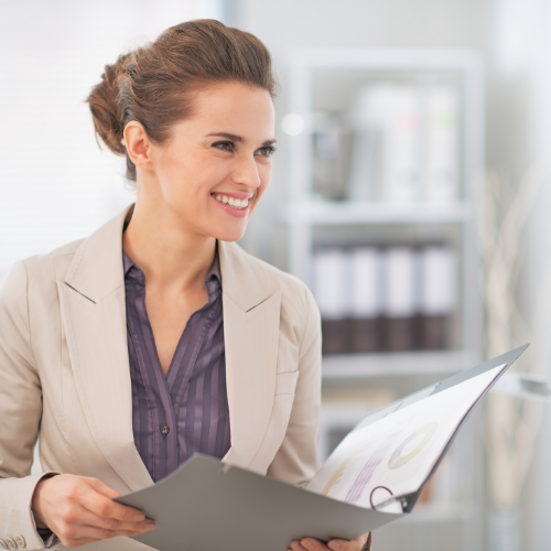 Smiling woman holding clipboard.