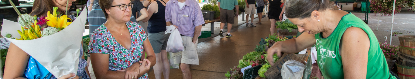 People shopping at a farmers market.