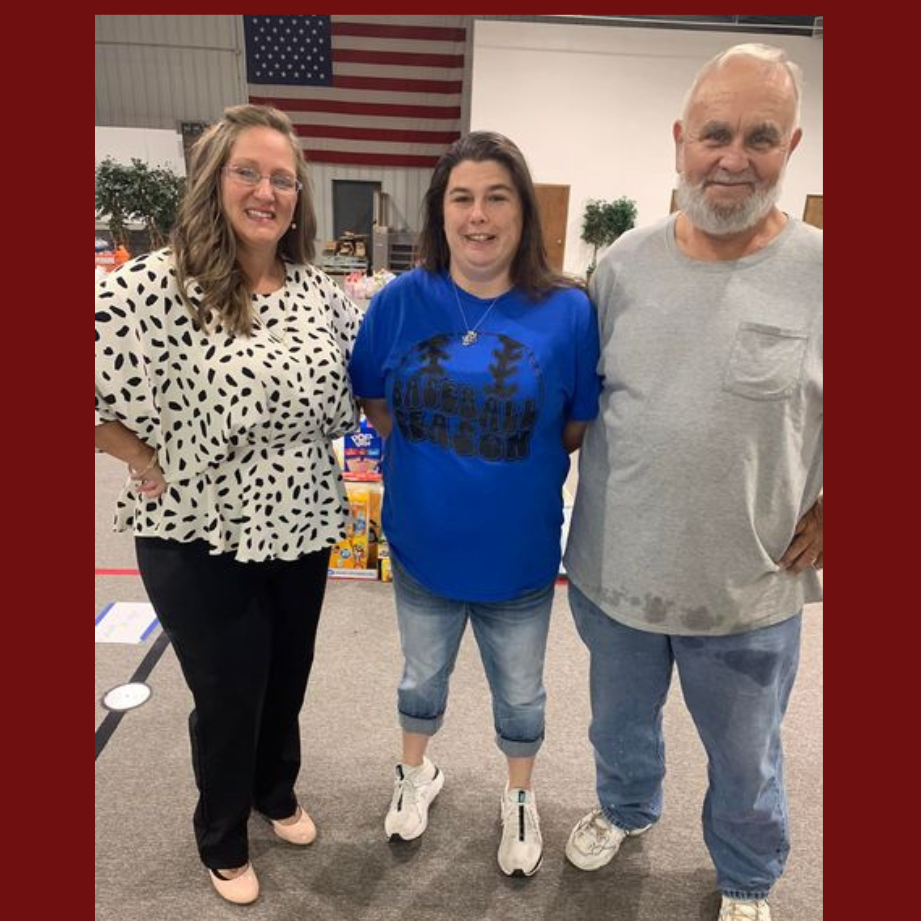 three adults standing beside bagged items