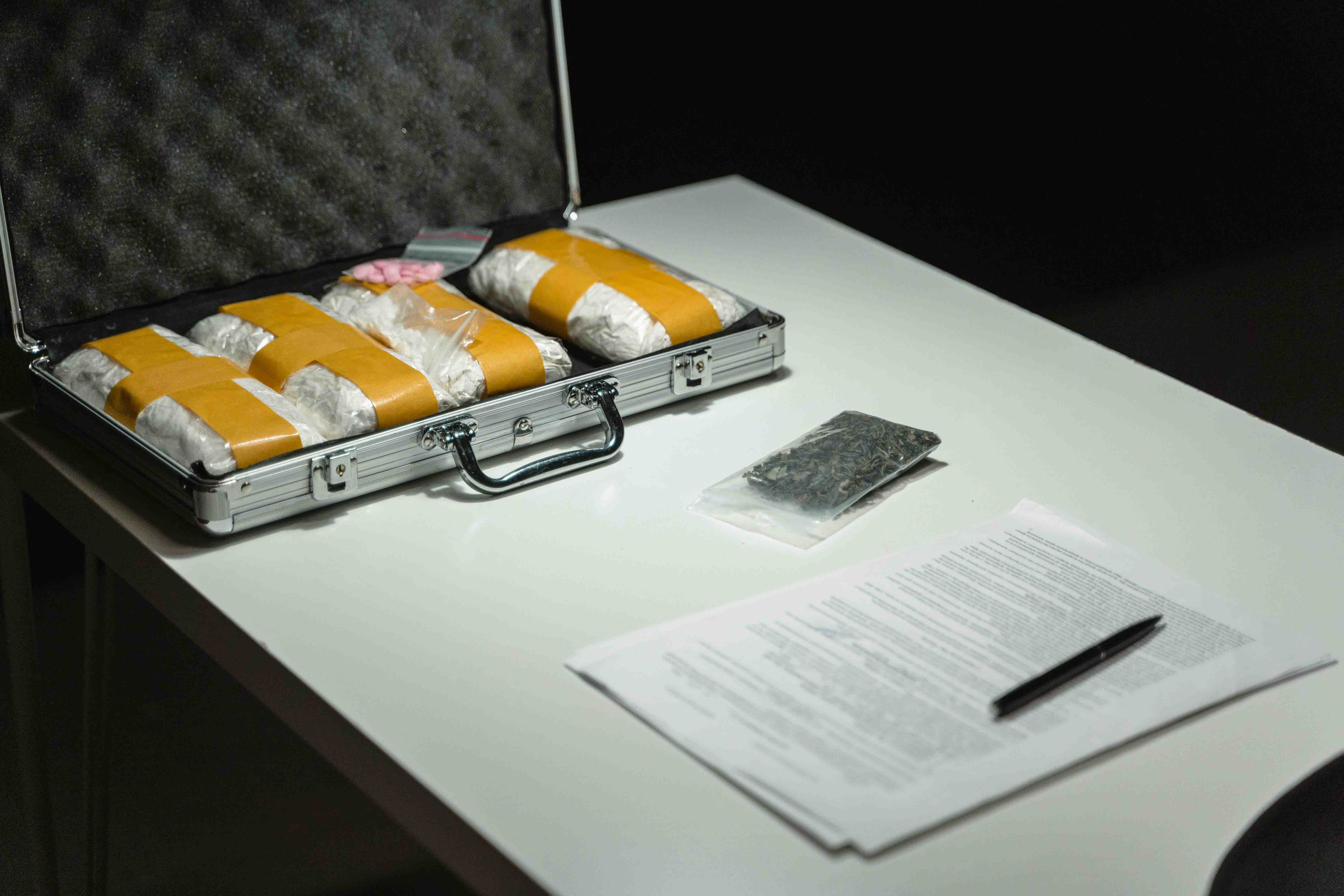 Briefcase filled with drugs on metal evidence table 