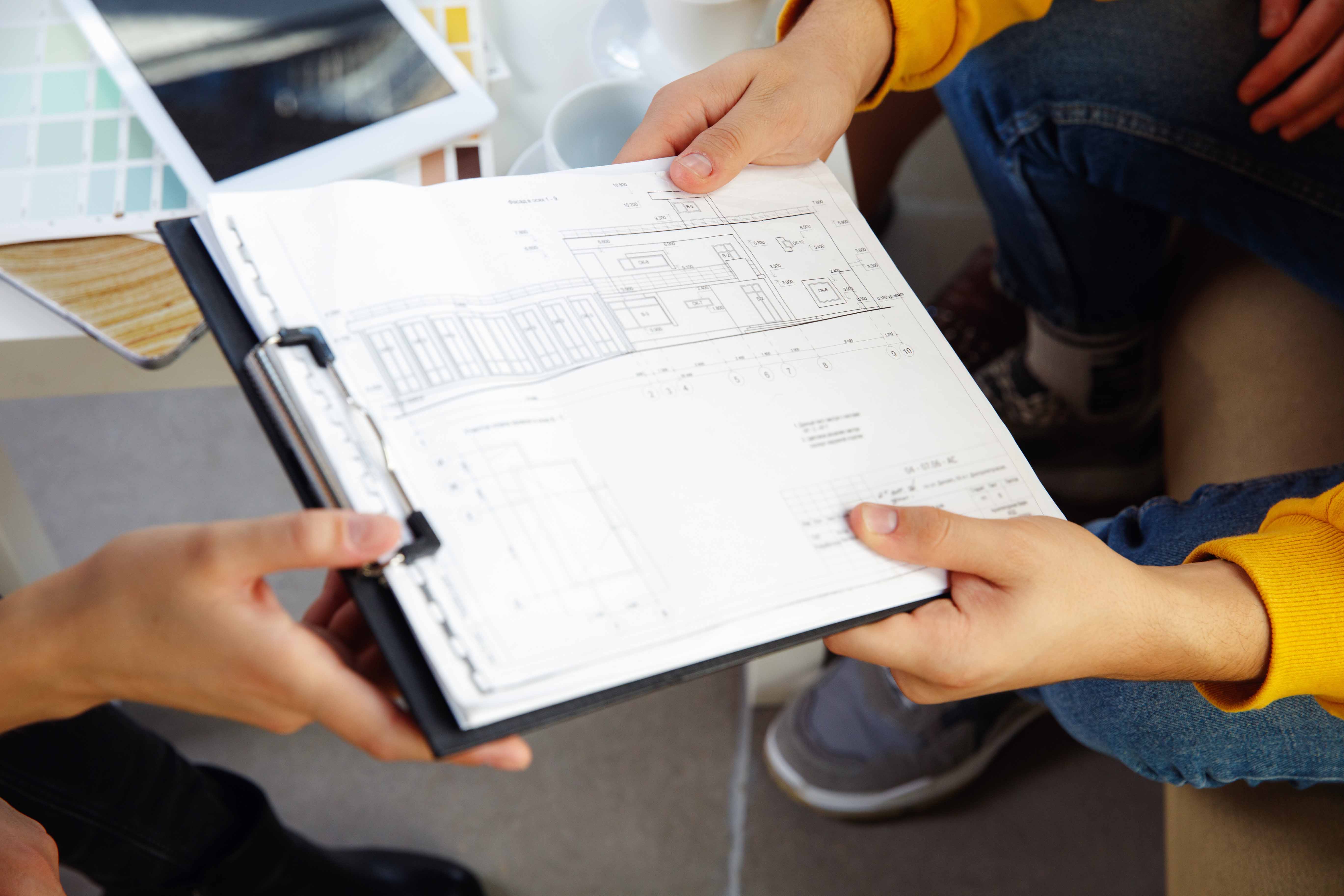 Close up of people looking at blueprint