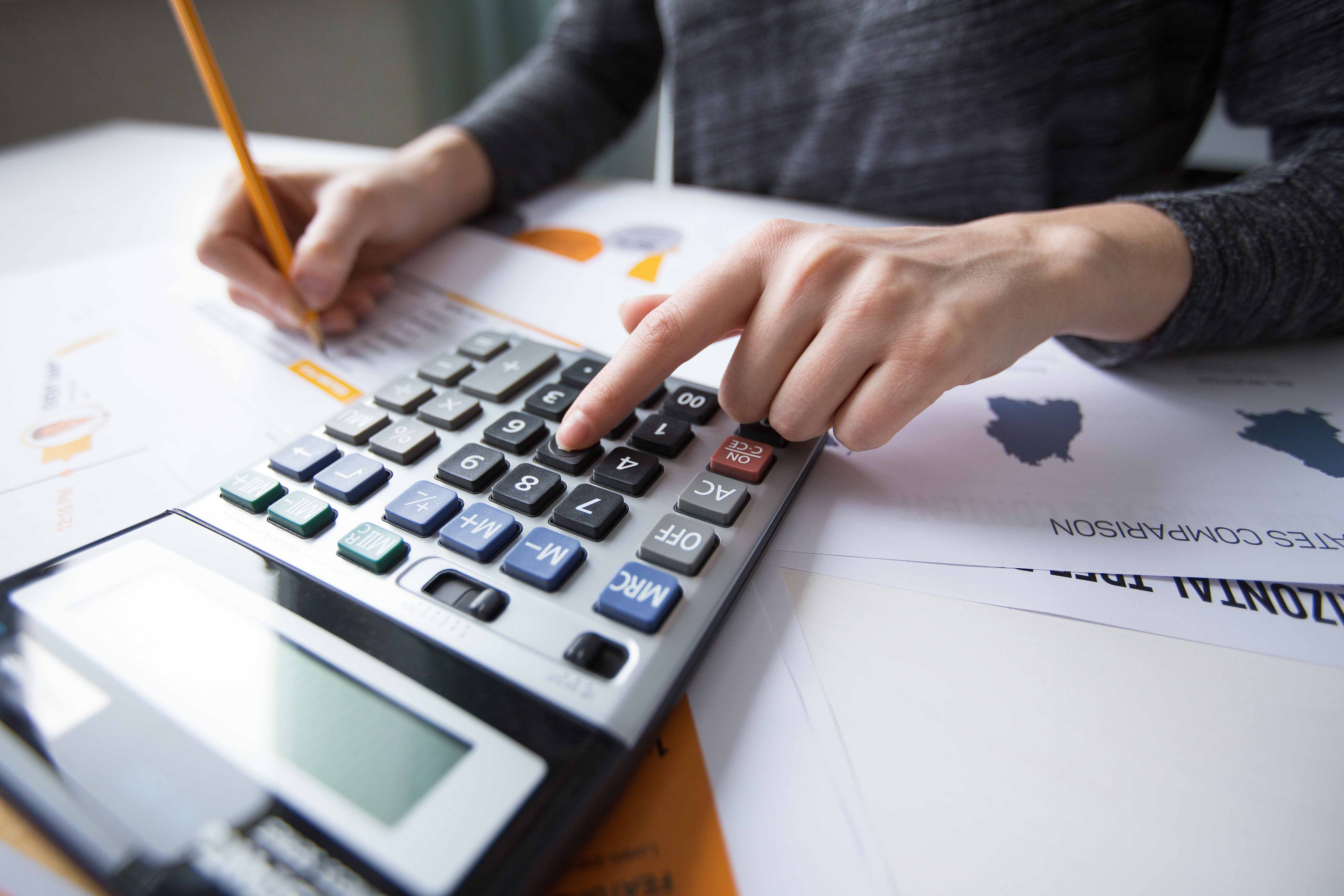 Close up of female hand using calculator