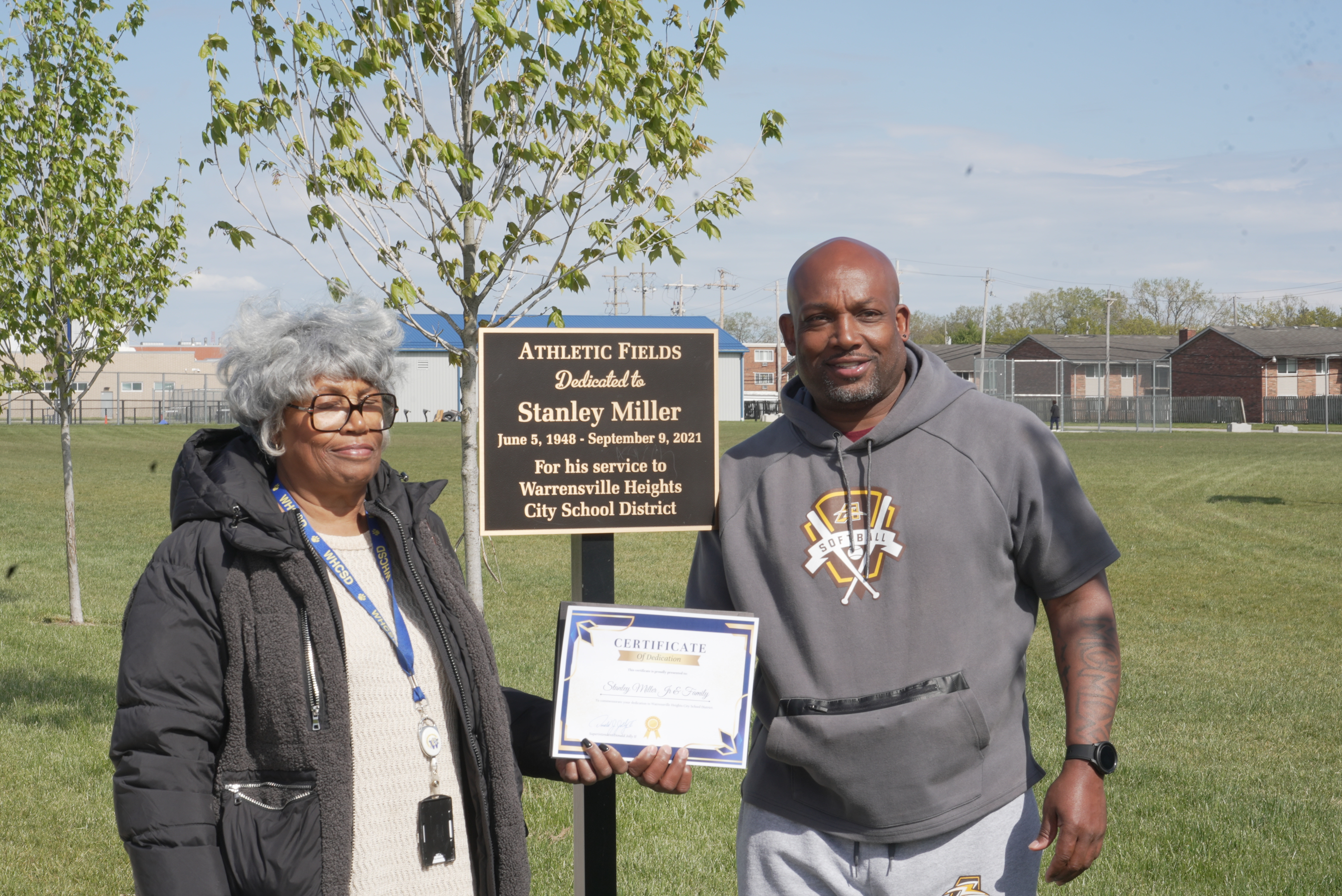 Photo of dedication plaque and family members