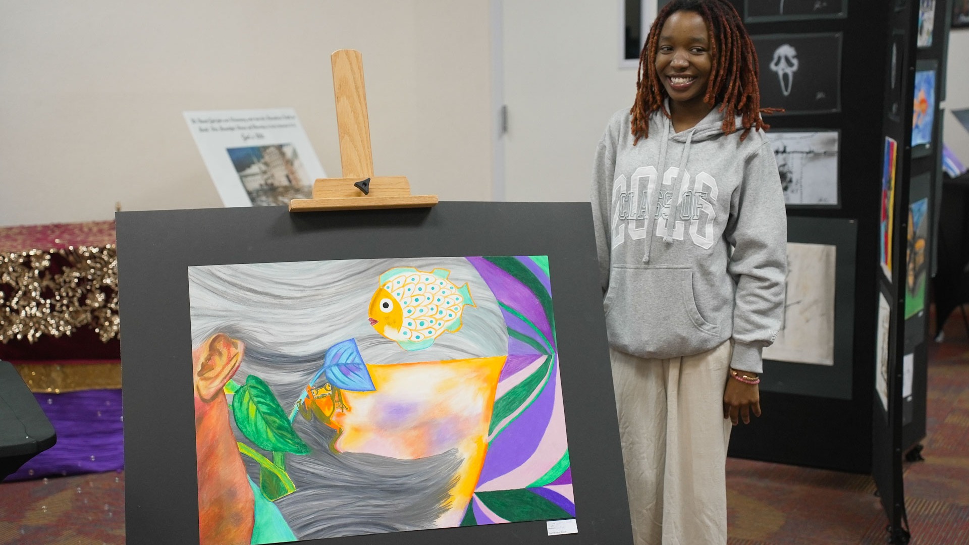 photo of high school art student in front of her art show painting
