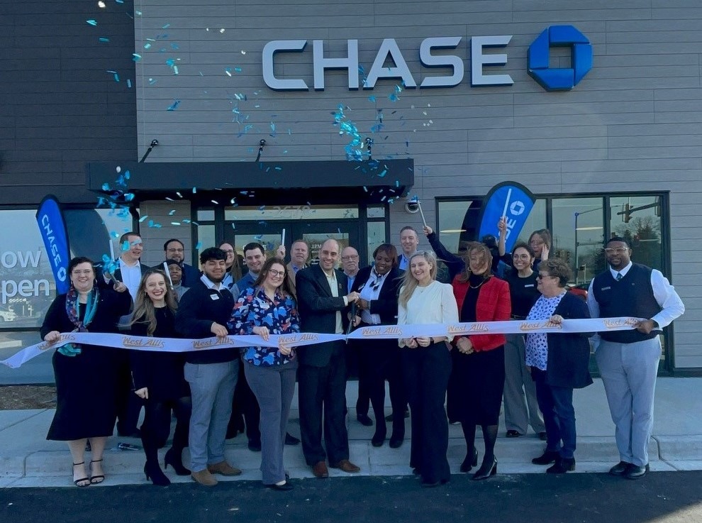 Photograph of Chase Bank ribbon cutting in West Allis showing smiling folks in front of new bank branch throwing confetti.