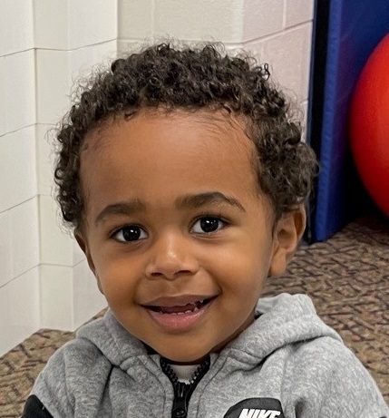 Child with gray sweater smiling