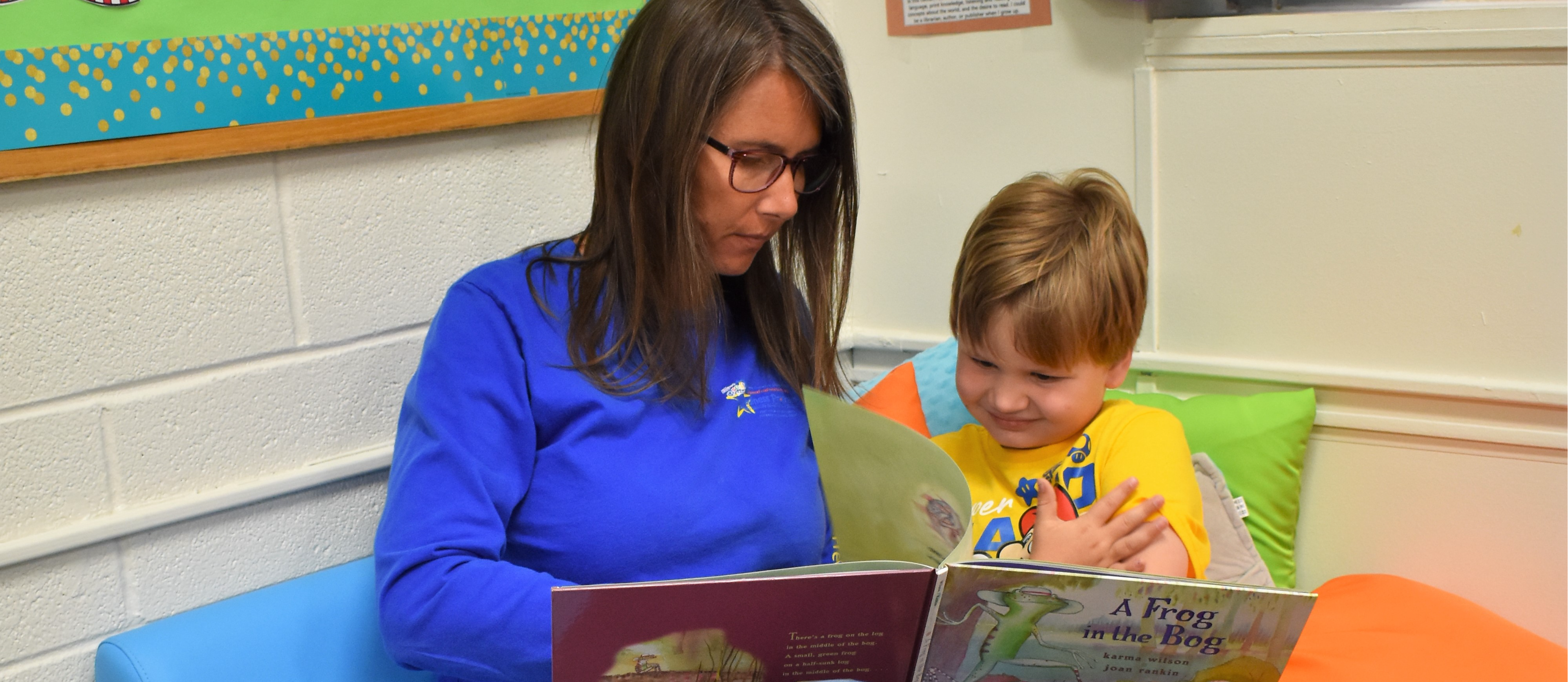 Staff member reading to preschool student