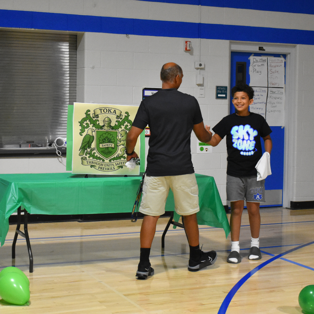 a student and teacher greeting each other after being picked for the same team