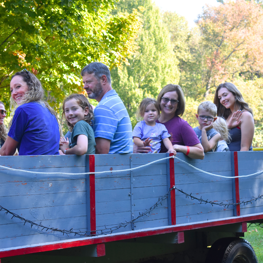 Photo of a wagon ride with people smiling at the camera