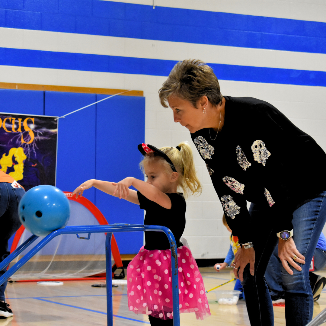 Teacher and student bowling in the gym