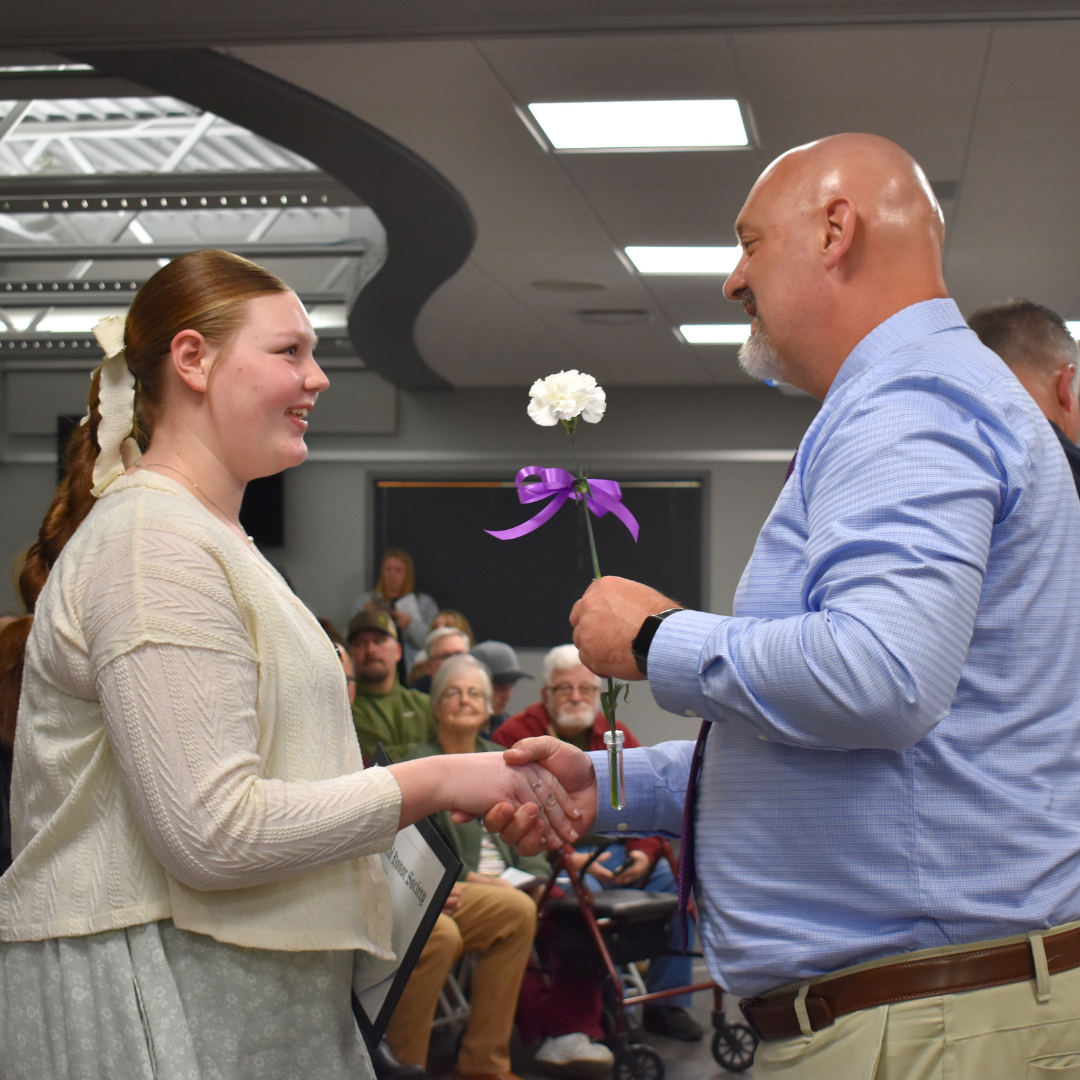 A student shaking the hand of the assistant principal