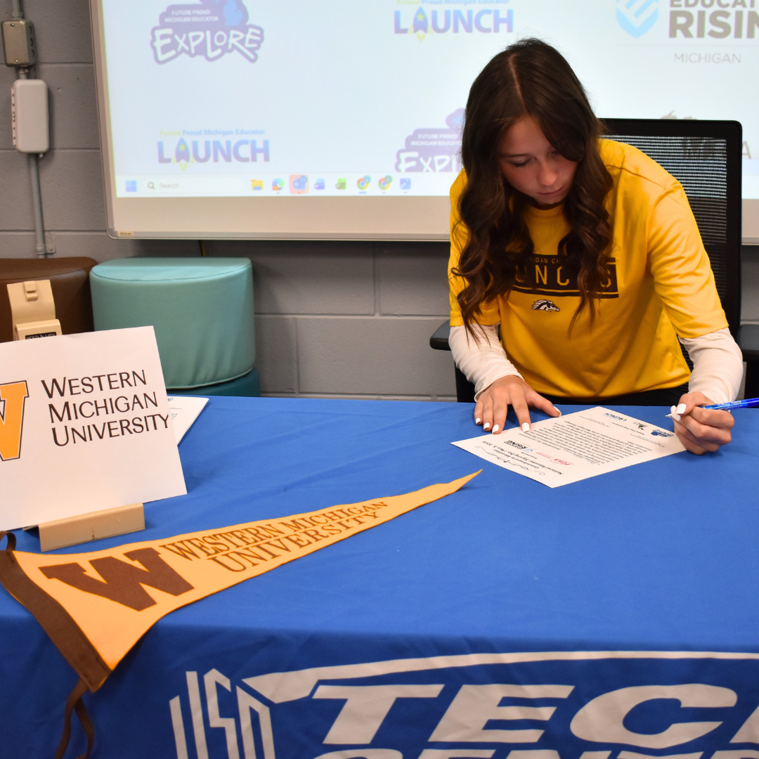 Photo of a student signing her commitment to education in the future