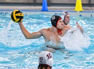 A person in a pool, holding a volleyball and surrounded by water.