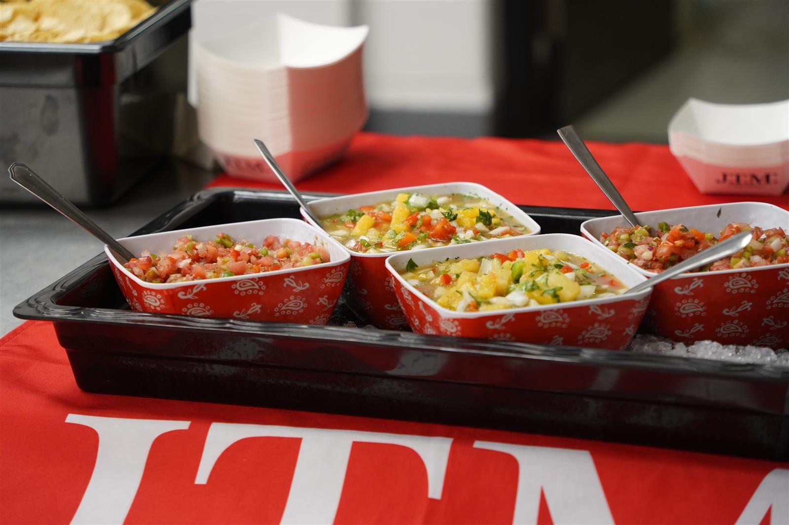 A tray of food, including salsa, is presented on a counter.