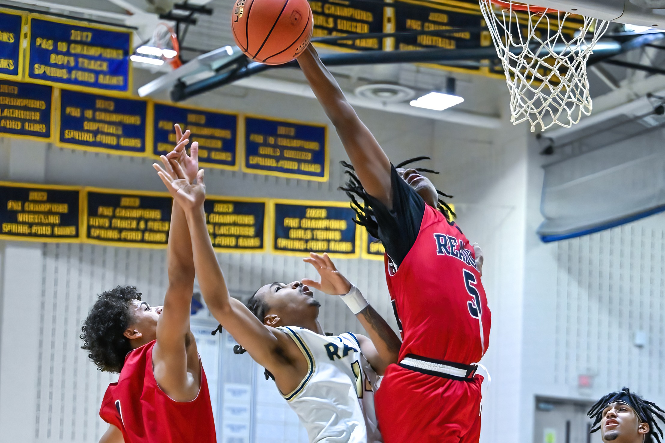 basketball players blocking a shot