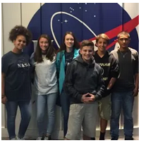 Nasa team posing in front of a space shuttle model.