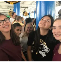 Young people posing for a photo at an indoor event.