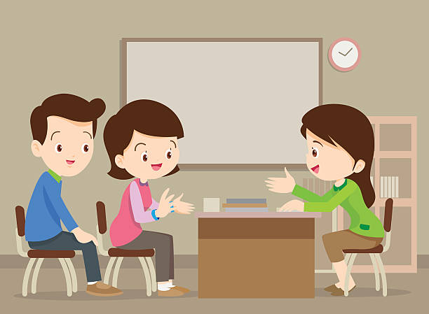 two parents conferencing with a teacher
