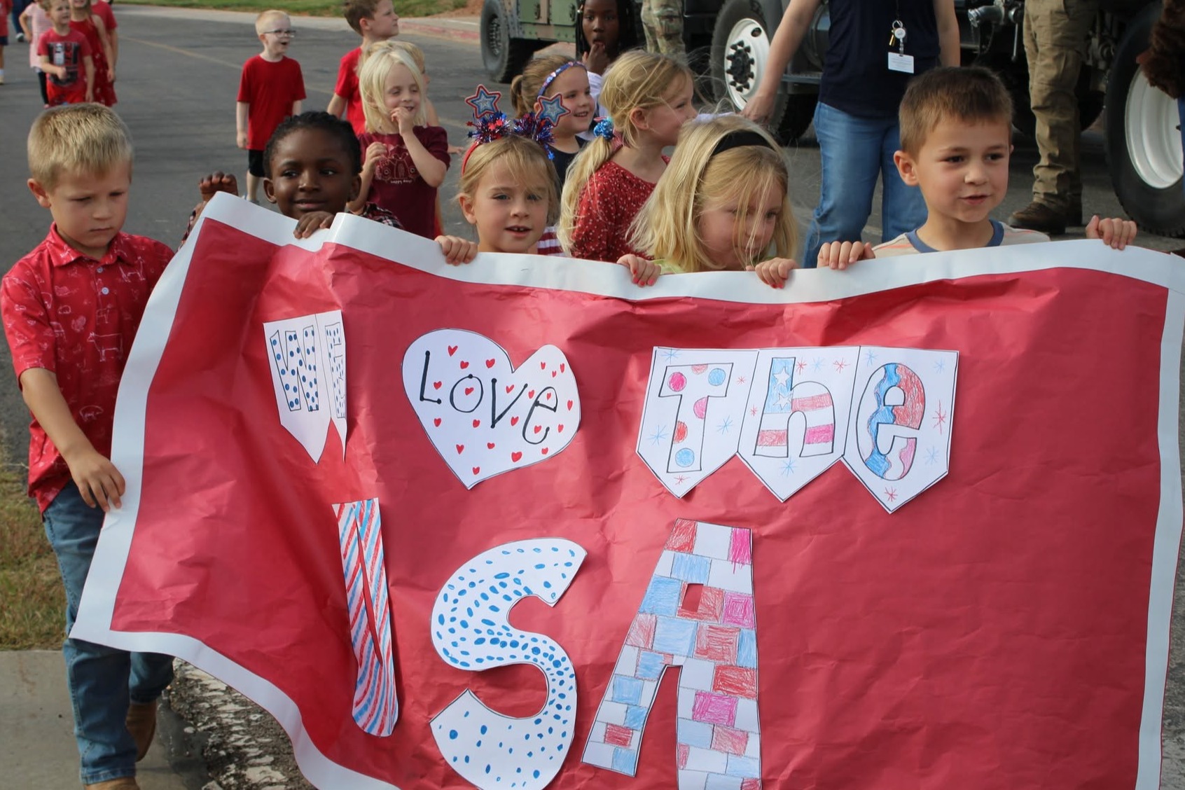 picture of students holding a banner saying we love the USA