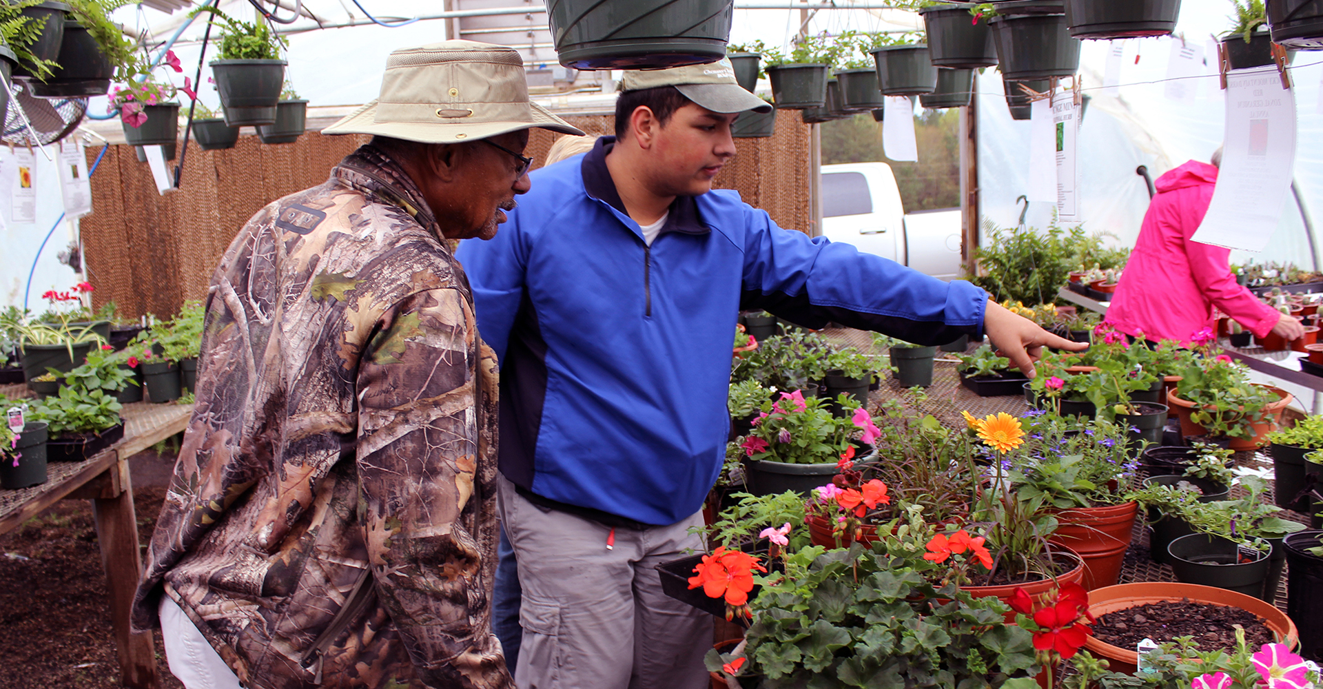 One of our horticulture students shows off flowers in our greenhouse.