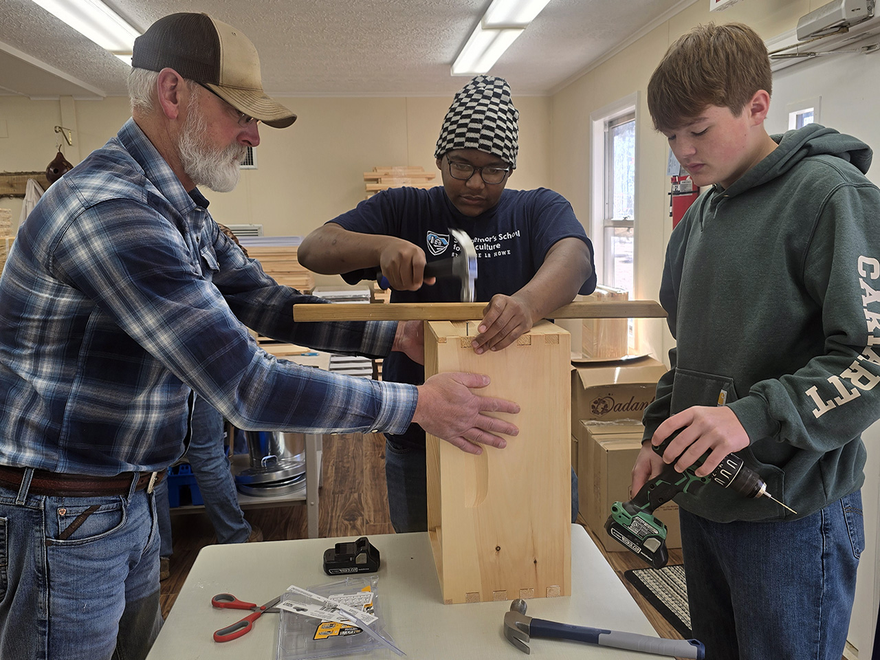 Mr. McCall works with students on building bee boxes.