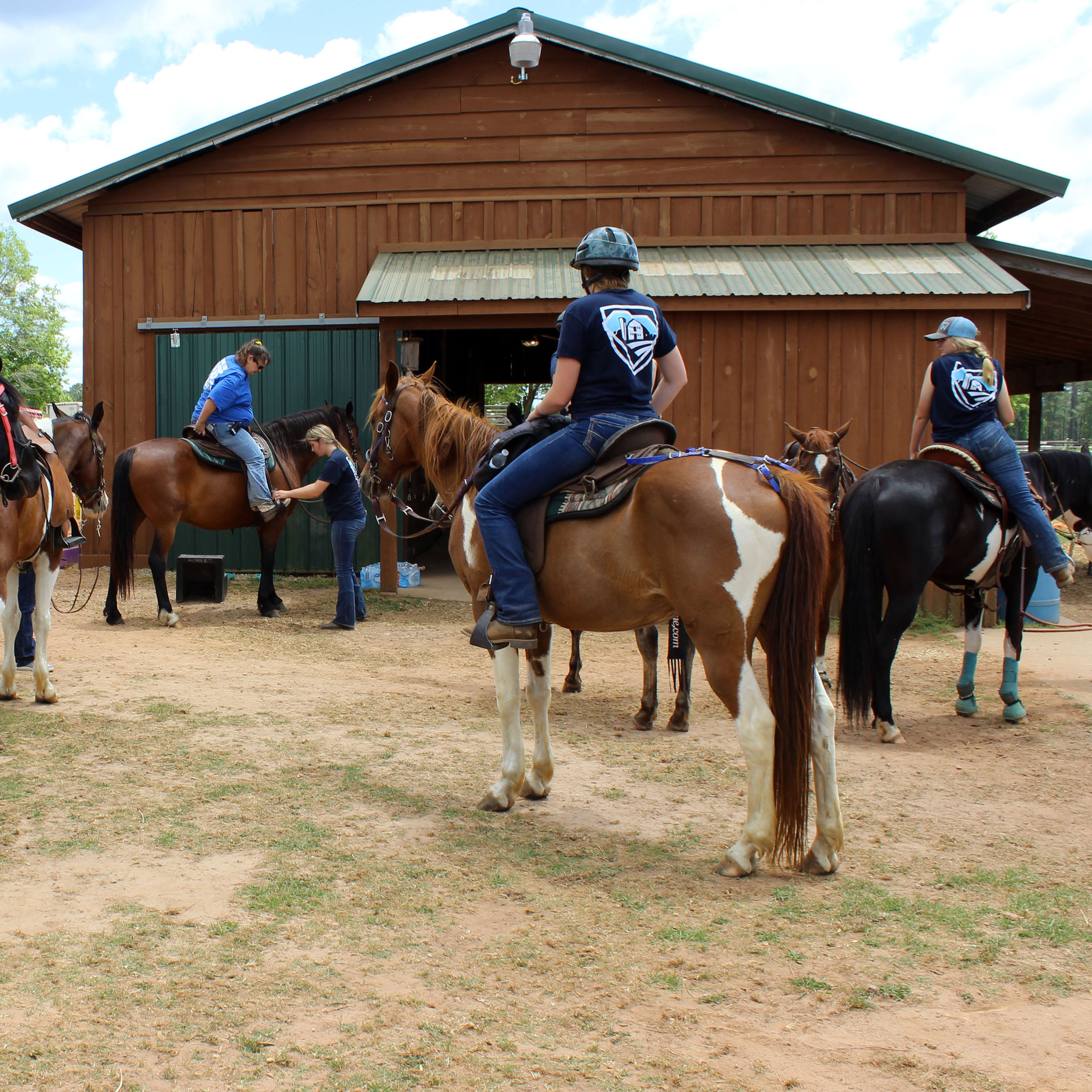 Prior to a trail ride, students prepare at the Equine Center.