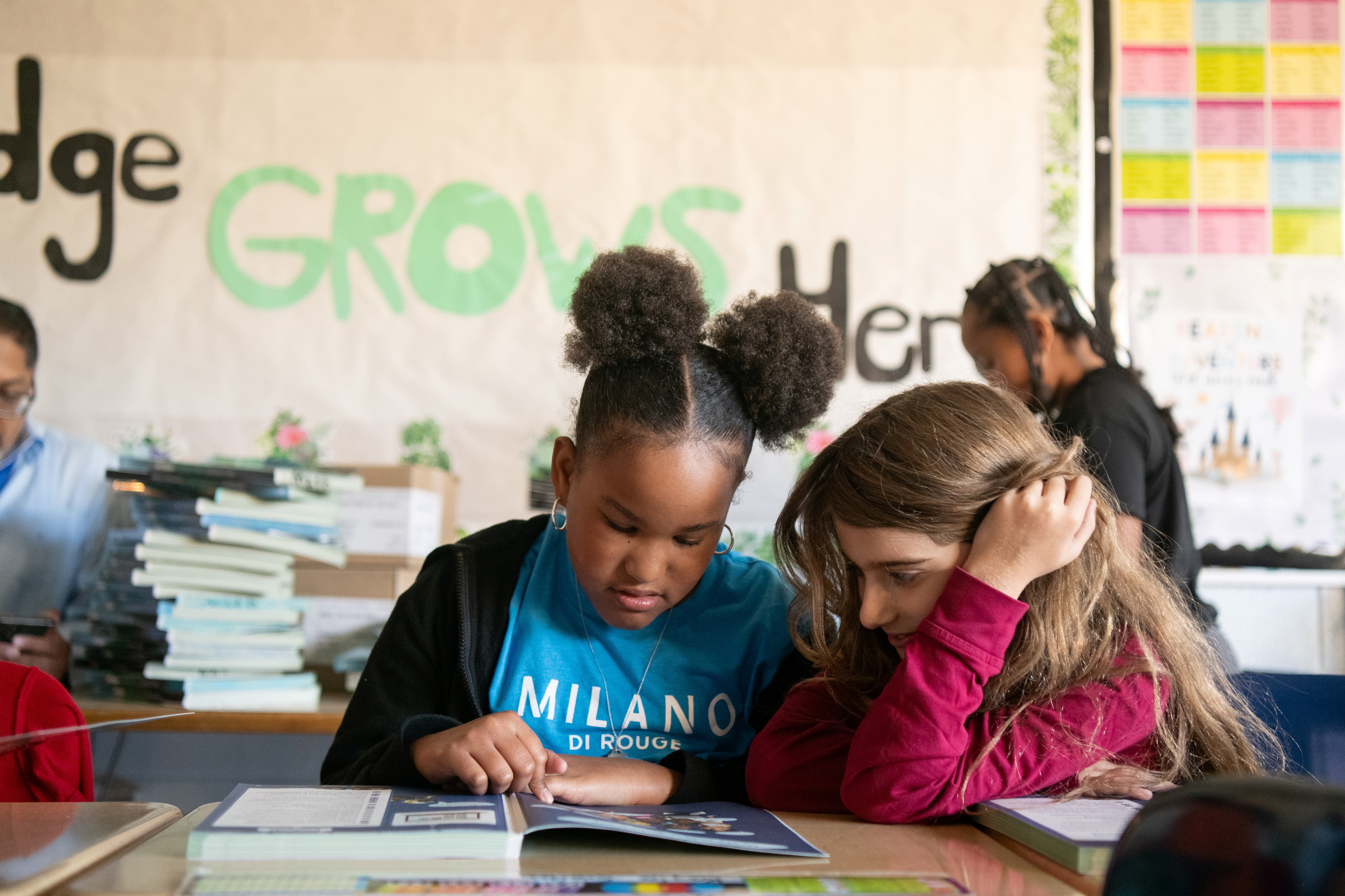 Two students reading a book together