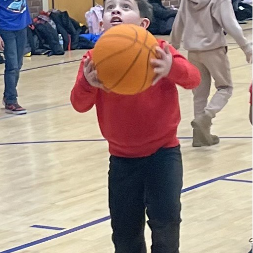 student shooting a basketball