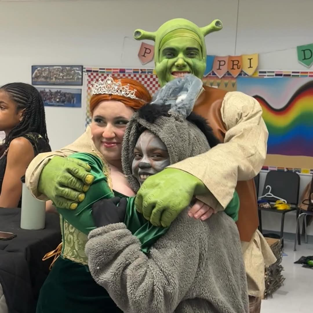 Shrek, Fiona, and Donkey hugging each other 