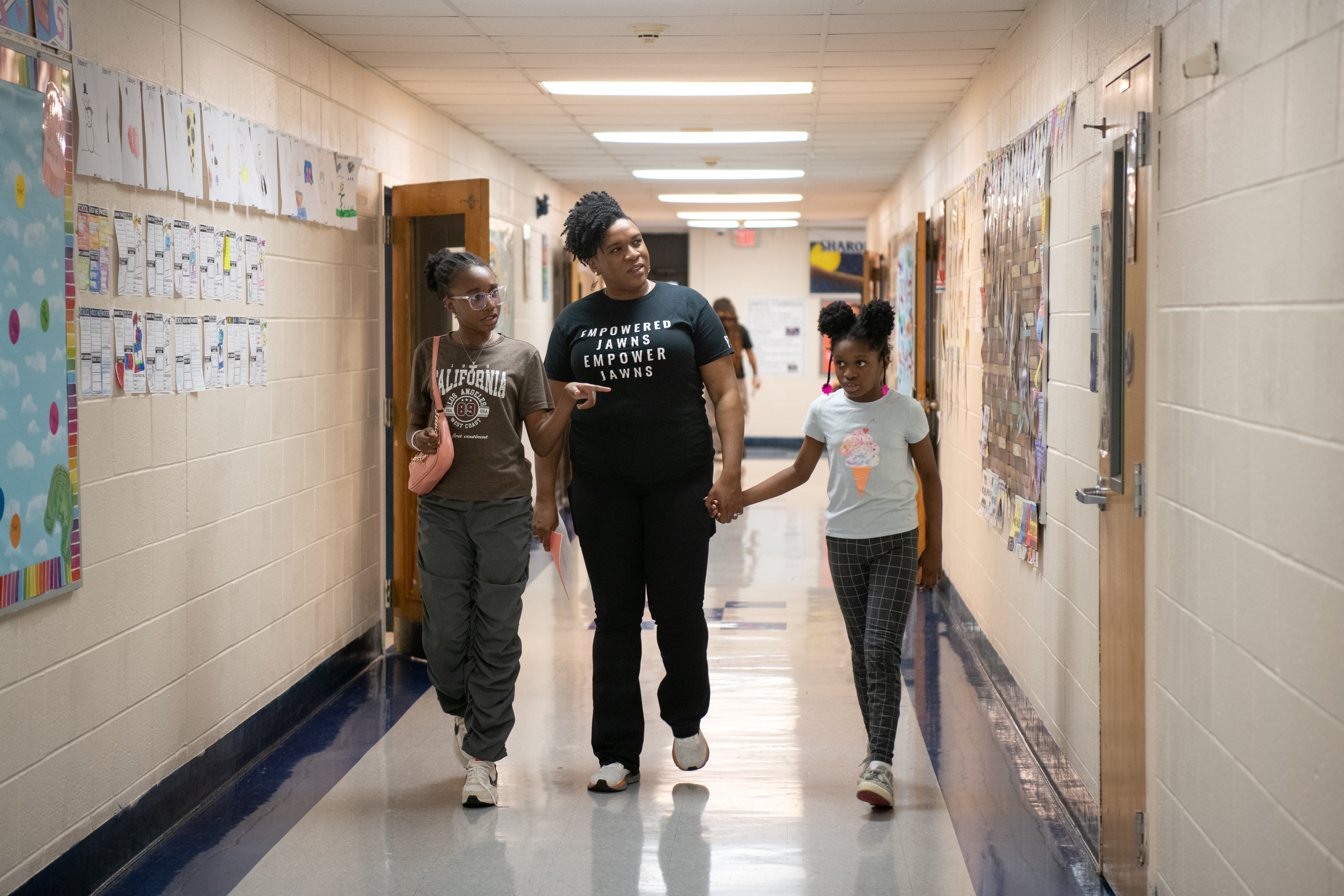 Mother and 2 daughters walking in the hallway