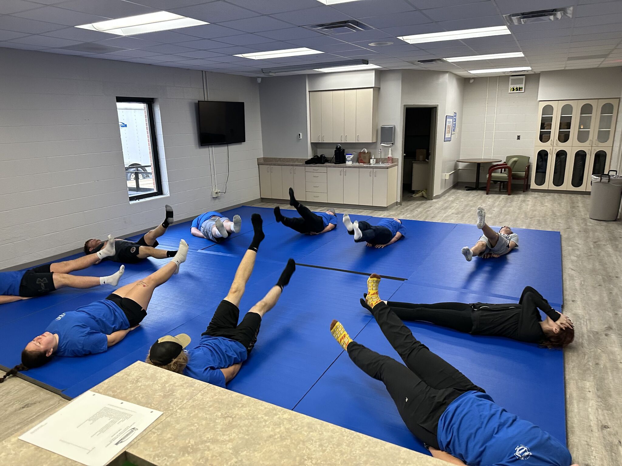 Students laying on mats doing weekly exercises.