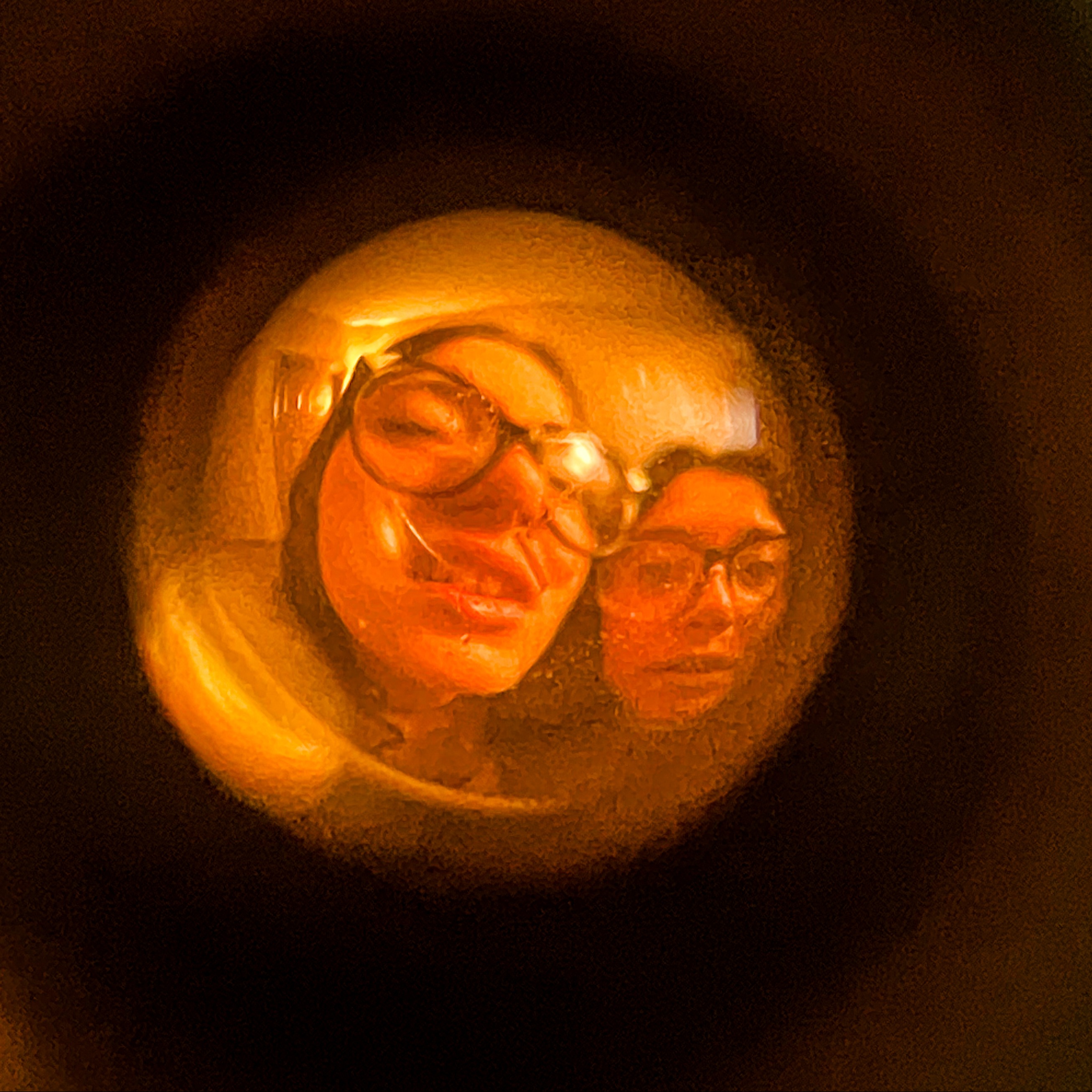 Two faces distorted through a peephole lens