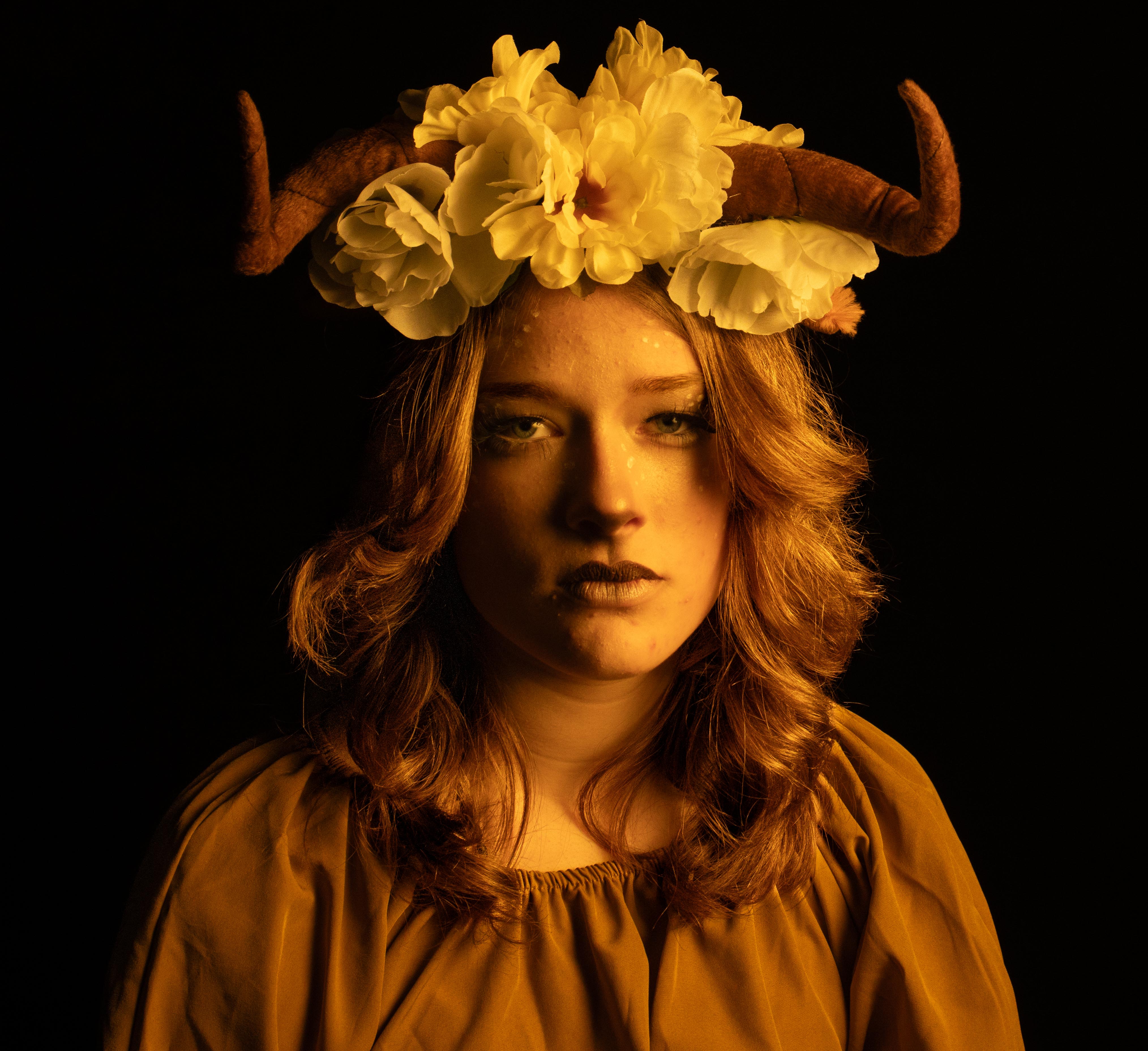 female wearing flowers and horns on her head