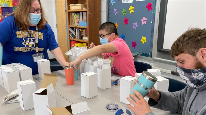 teacher and students with boxes a cups