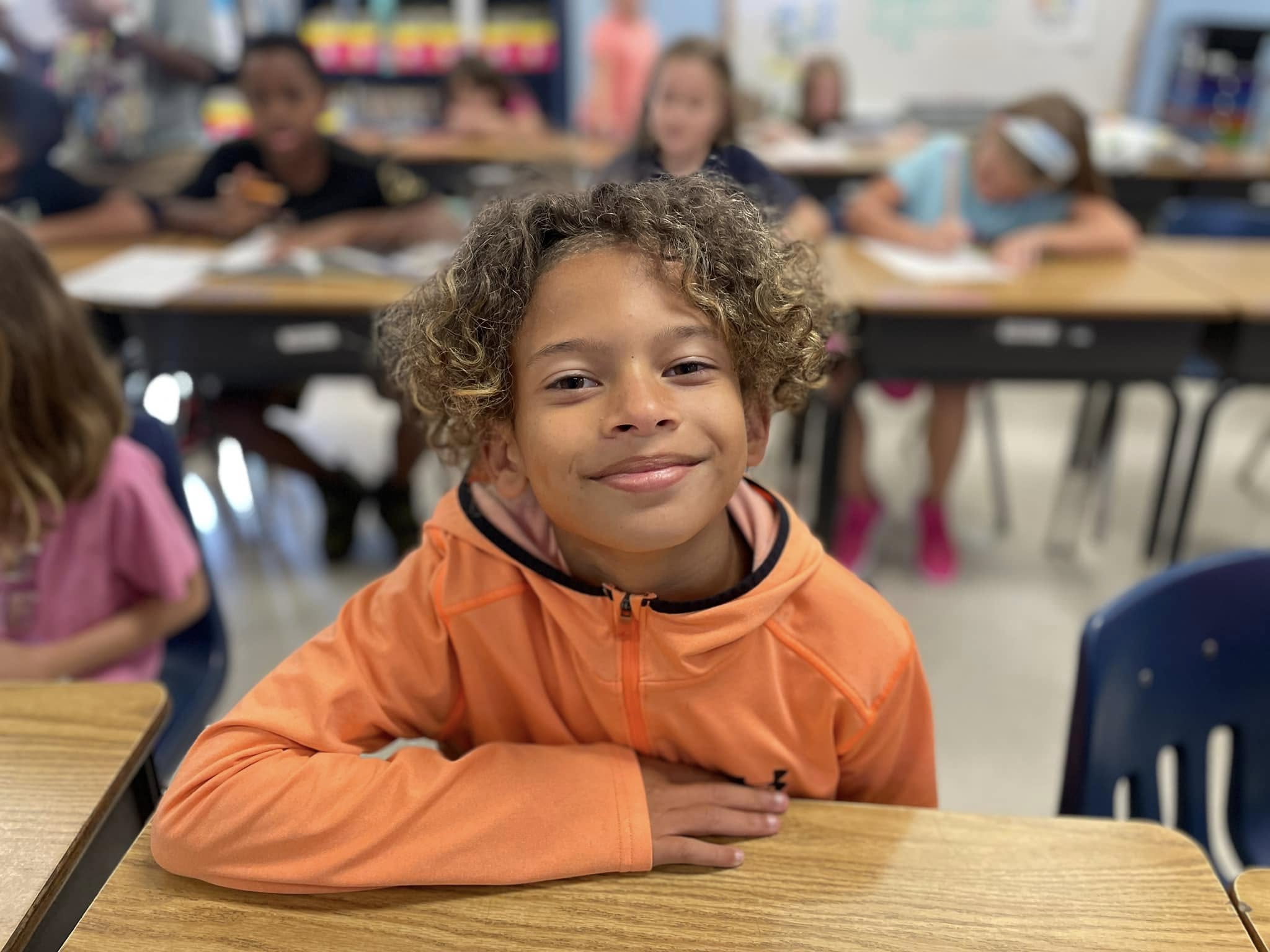 child smiling at a table