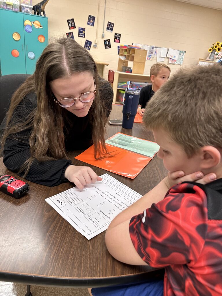 Kids club - a teacher is helping a child with homework