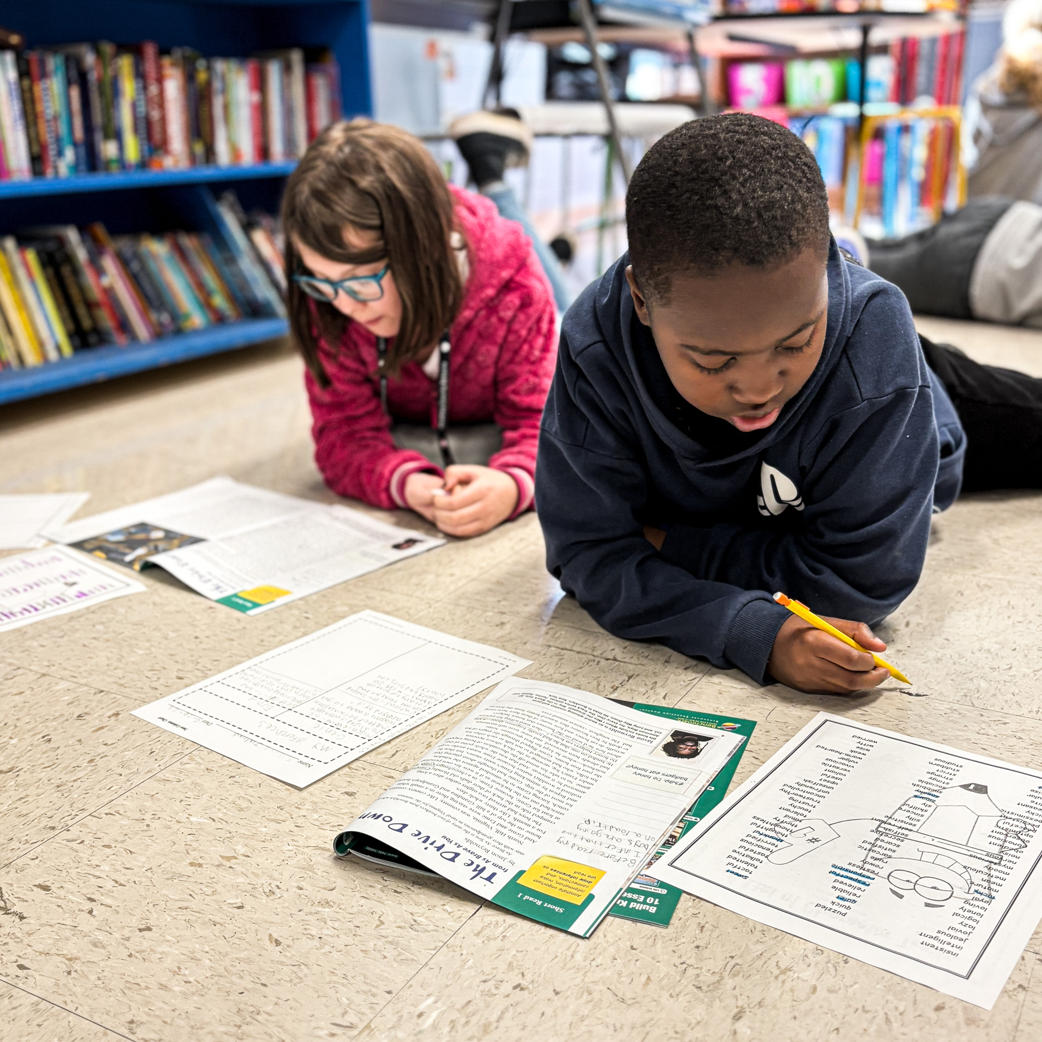 children working on their work in the floor